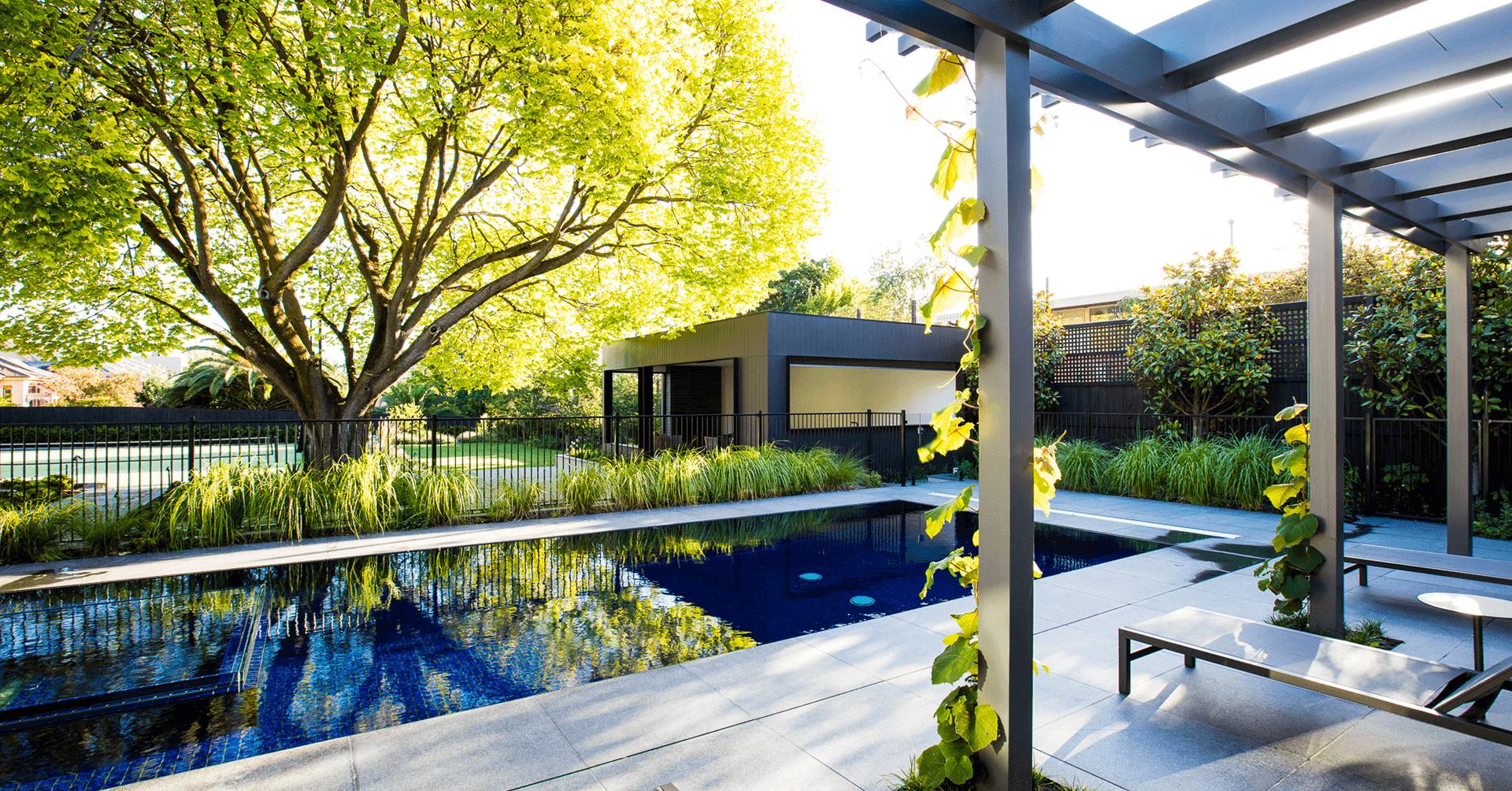 Luxury pool area with pergola and lush gardens